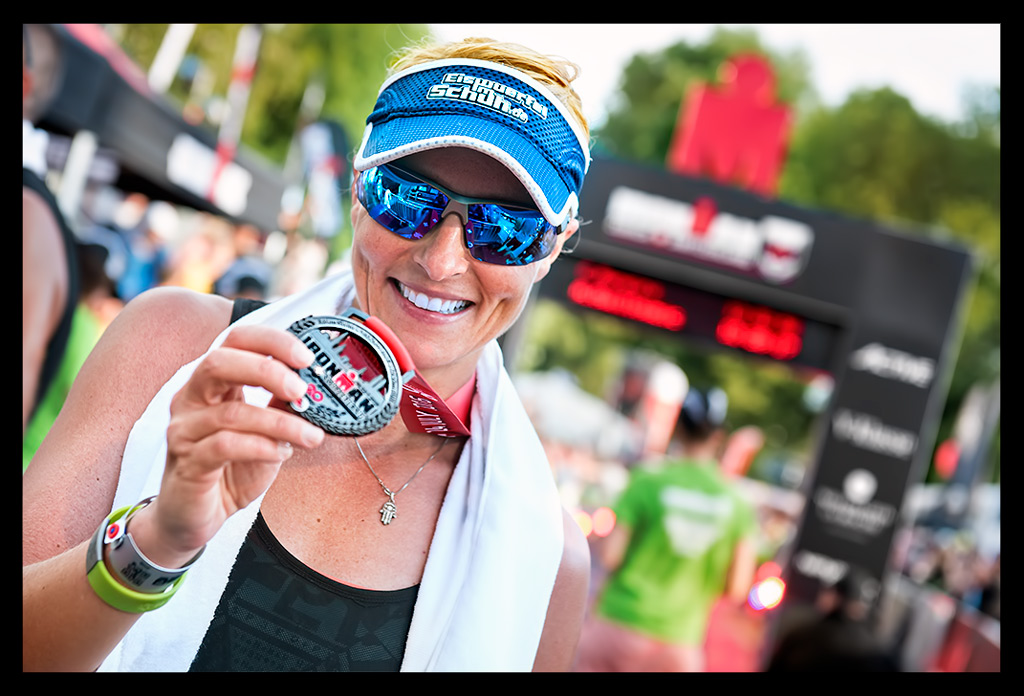 Triatletin Nadin Eule-Mau Ironman Switzerland Zurich erste langdistanz im Ziel zeigt grosse Medaillie und lacht vor dem Zielbogen im Finish