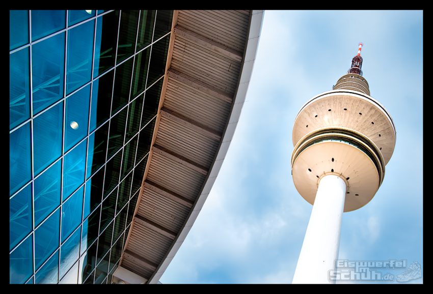 Messehalle und Fernseh-Turm in Hamburg vor blauem Himmel.
