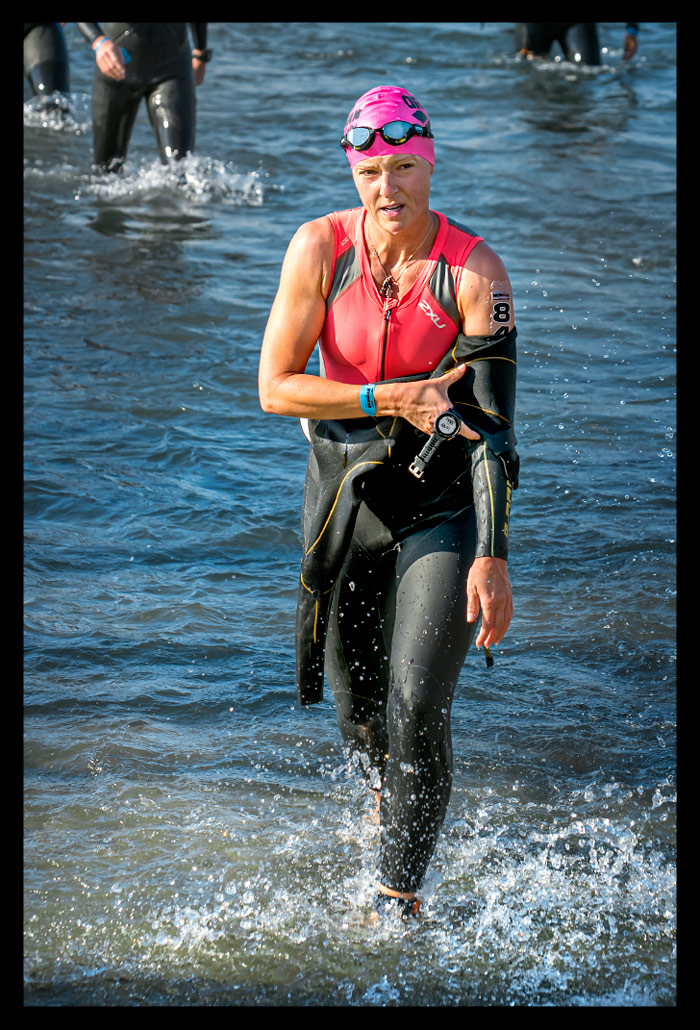 Ironman Frankfurt Langener Waldsee Langdistanz Triathletin kommt aus Wasser Neoprenanzug am ausziehen Trisuit farbe Orange drunter Rosa Badekappe