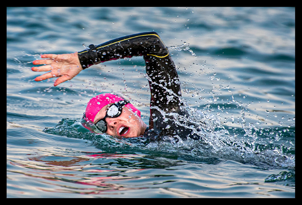 Ironman Frankfurt Langener Waldsee Triathletin Neopren Sailfish im Wasser Atmung links Arm aus Wasser Rosa Badekappe kämpferisch auf Langdistanz beim Schwimmen