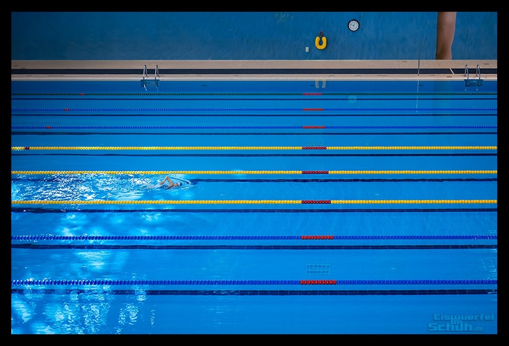 Triathletin in schwimmbecken halle training einsam alleine blaues wasser beckenrand licht spiegelt kraulen