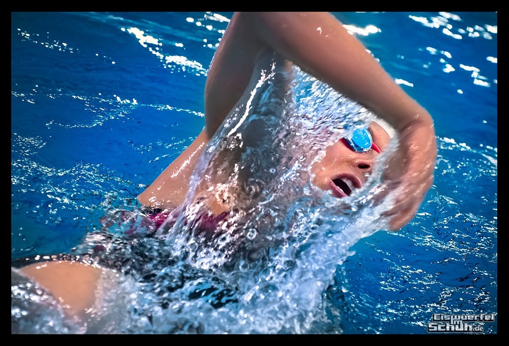 triathletin schwimmt krault in schwimmhalle arm aus wasser atmung rechts spritzer mund offen Triathlon Training Tipps für entspanntes Schwimmen