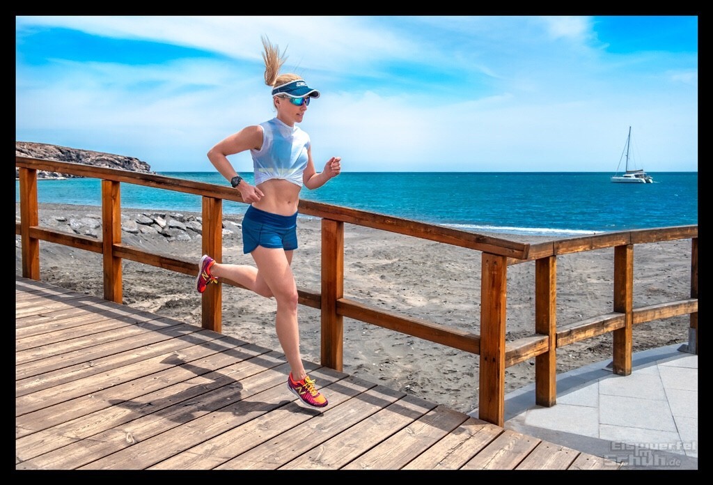 Triathletin nadin eule am Strand mit dem Garmin Running Dynamics Pod sommerlich outfit mehr als sexy bauchfrei kurze hose blonde haare zopf im wind strand boot wasser 