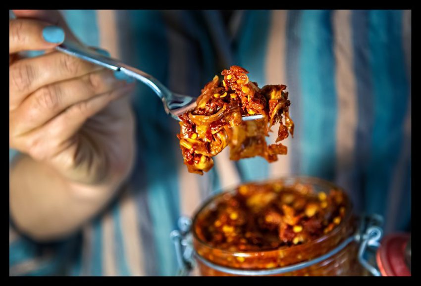 Veganer Chinakohl Kimchi auf Gabel und geöffneter Weckglas