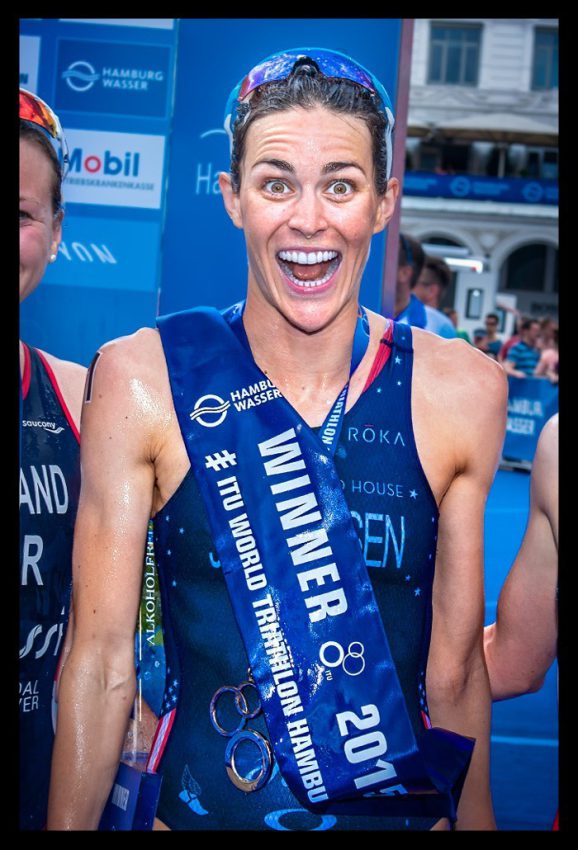 Gwen Jorgensen siegerin Triathlon hamburg itu lacht in kamera naße haut champagner dusche mund aufgerissen grosse augen siegerschleife