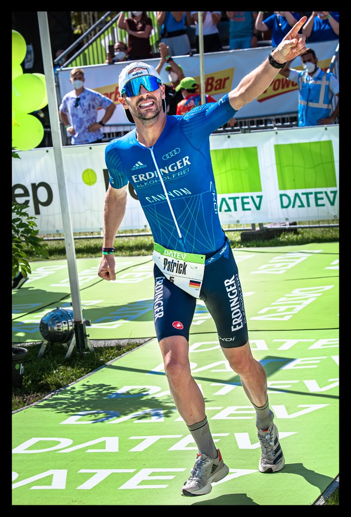 Patrick Lange Weltmeister Ironman Challenge Roth Sieger Zieleinlauf Stadion Jubelt Zuschauer Datev Werbung sommerlich lacht freudig