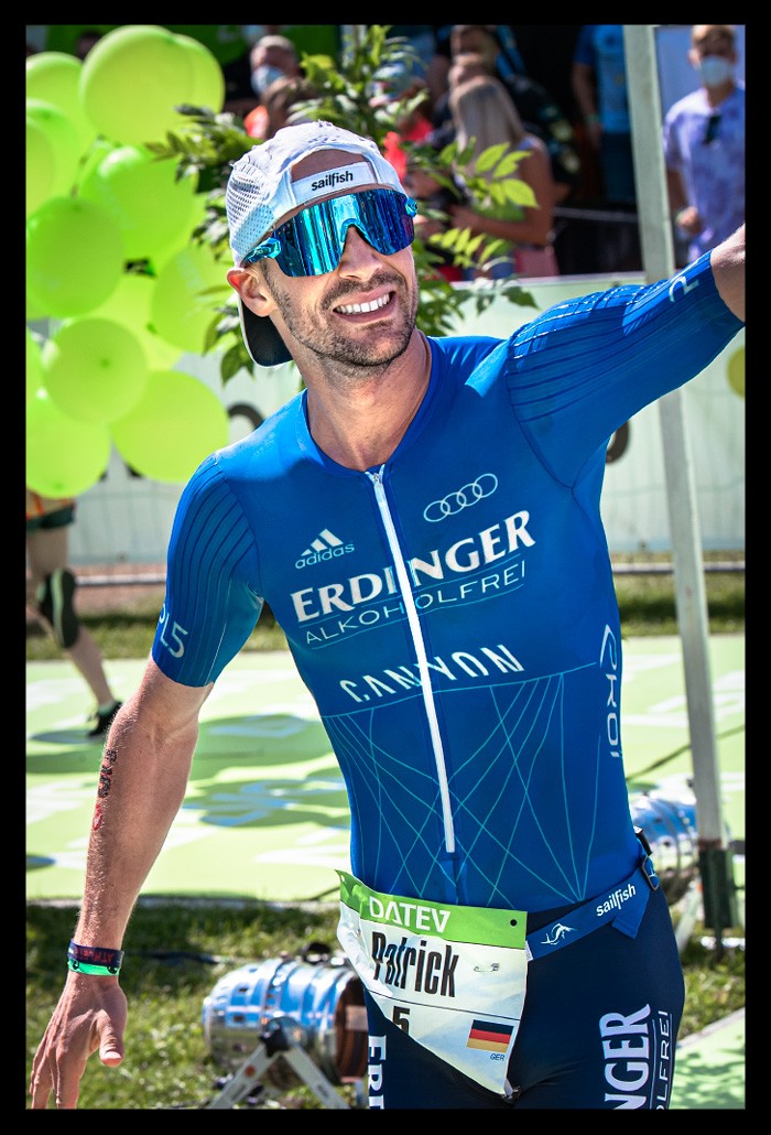 Patrick Lange Weltmeister Ironman Challenge Roth Sieger Zieleinlauf Stadion Jubelt Zuschauer emotionen Datev Werbung sommerlich lacht freudig ERdinger Canyon Werbung nahaufnahme