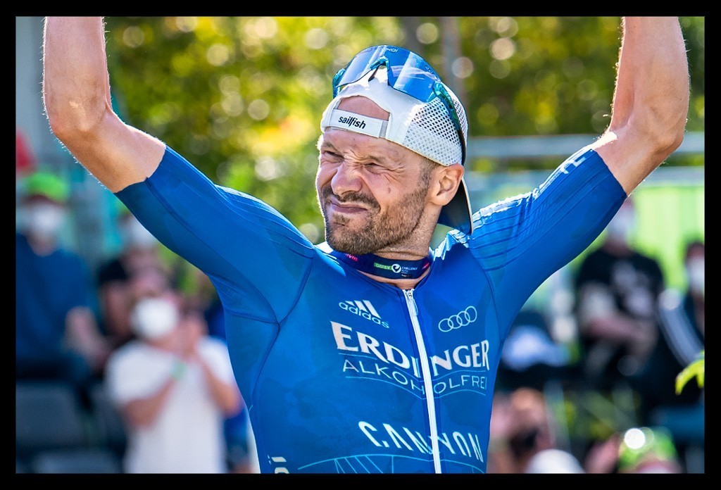 Patrick Lange Weltmeister Ironman Challenge Roth Sieger Stadion Jubelt Zuschauer Arme Hoch Emotionen im Gesicht freudig nahaufnahme
