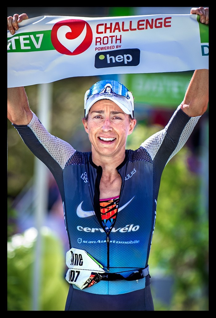 Anne Haug Weltmeisterin Ironman Siegerin Challenge Roth Ziel Schleife über Kopf Tri-suit blau cervelo hep lacht