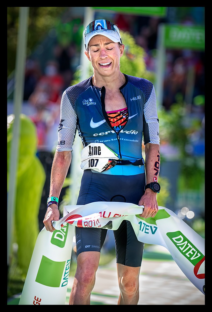 Anne Haug Weltmeisterin Ironman Siegerin Challenge Roth Ziel Schleife Tri-suit blau erschöpft