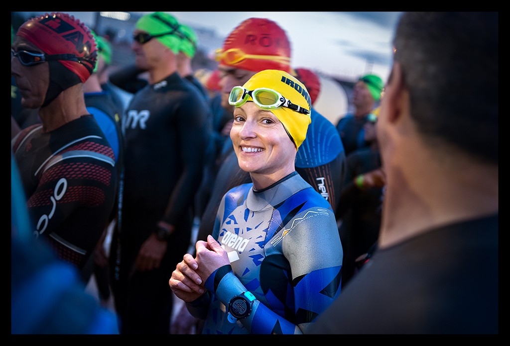 Triathletin und Bloggerin Nadin als Schwimmerin in Gruppe von Triathleten mit Badekappe, Neoprenanzug, Schwimmbrille lächelnd während des Ironman Arizona Tempe am Wettkampfmorgen