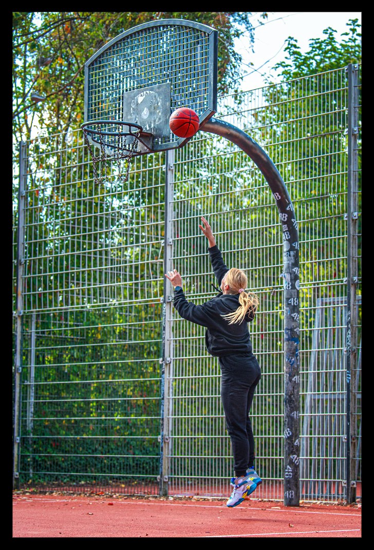 Frau mit Garmin Smartwatch spielt Basketball und AIR Jordan Schuhe streetball court sommerlich wurf nba ball spalding