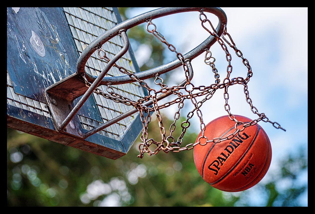 Spalding Basketball durch Metall Netz auf Court bei Sonnenschein. Garmin Multisportuhr Test von Nadin eiswuerfelimschuh