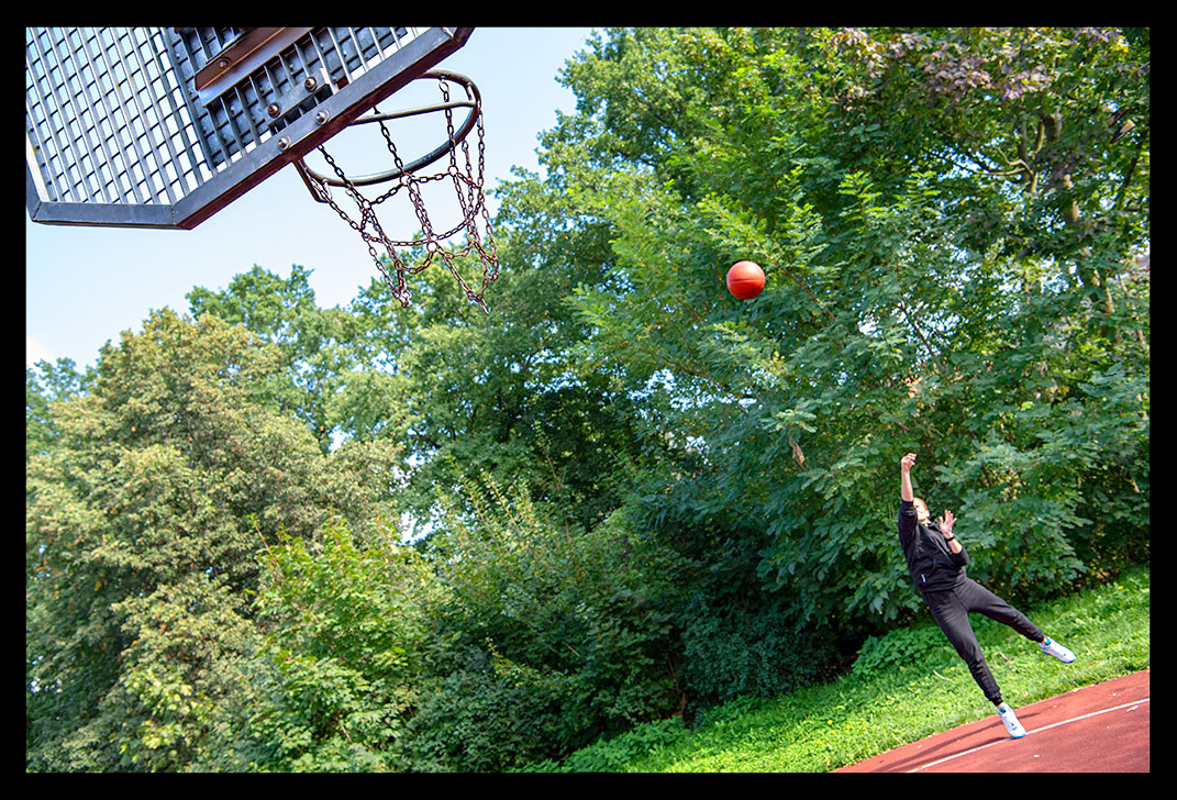 Frau mit Garmin Smartwatch spielt Basketball und AIR Jordan Schuhe streetball court sommerlich wurf dreier nba ball spalding