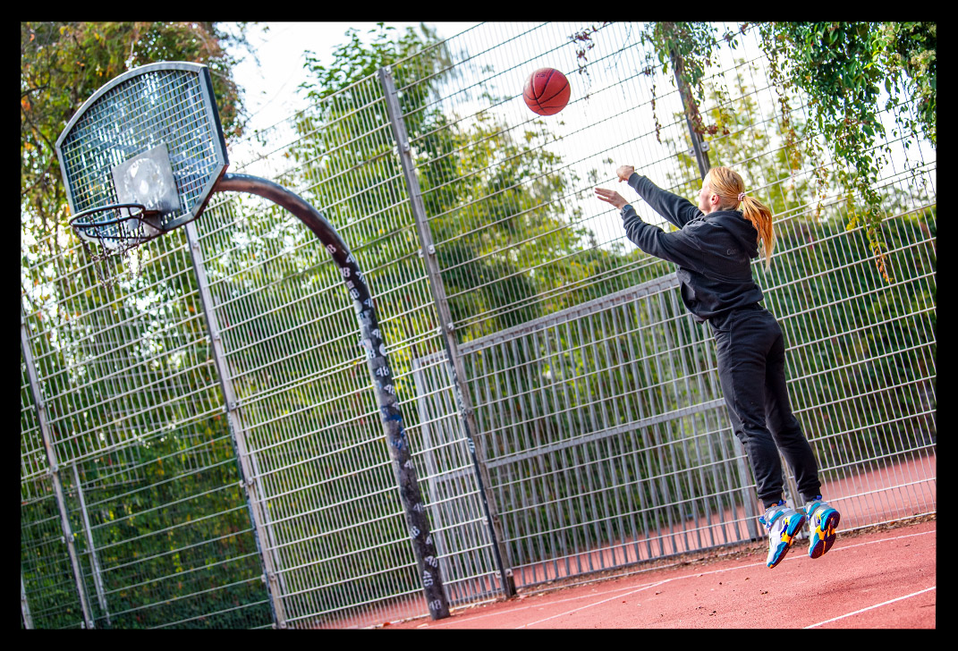 Frau spielt Basketball und AIR Jordan Schuhe streetball court sommerlich wurf dreier nba ball spalding