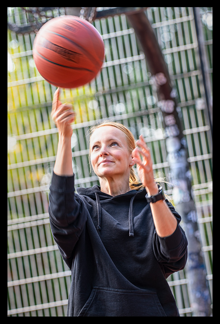 Nadin von eiswuerfelimschuh.de testet die neue Garmin beim Basketball spielen und dreht den Ball auf einem Finger. Sie lächelt und blickt auf den Ball.