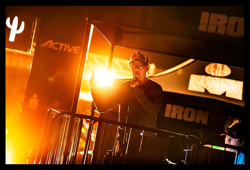 Mike Reilly voice Ironman-Arizona-Tempe finishline warm light stage with micro and basecap