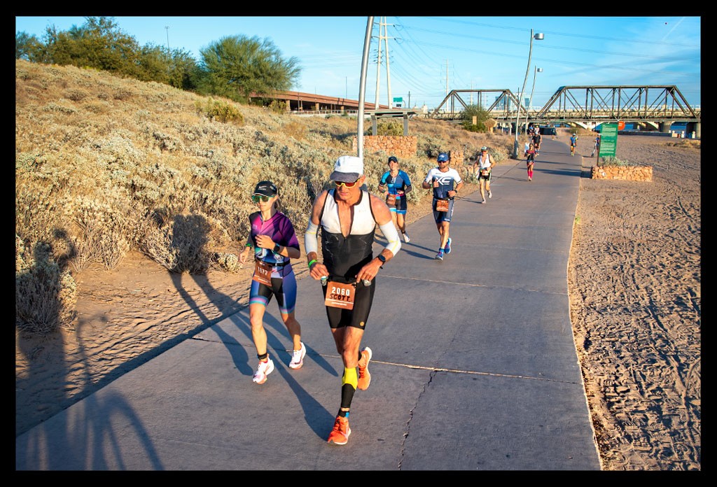 Ironman in Tempe Arizona USA Läufer auf der Laufstrecke mit Brücke und Strand im sonnenuntergang
