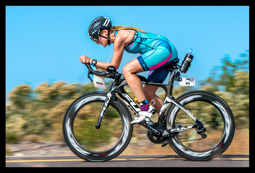 Triathletin deutschland Radstrecke Ironman Arizona TriSuit blau schwarzes Zeitfahrrad fuji bikes landschaft kakkteen asphalt glüht sommer hitze trocken kämpfen
