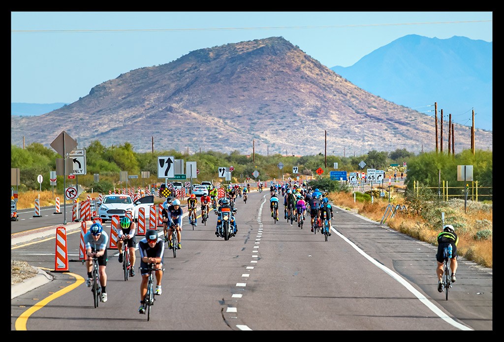 Triathleten auf der Radstrecke beim Ironman Arizona in TriSuit auf Zeitfahrrad