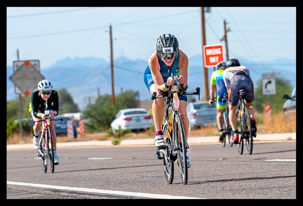 Triathletin und Bloggerin auf der Radstrecke beim Ironman Arizona in TriSuit auf Zeitfahrrad lachend