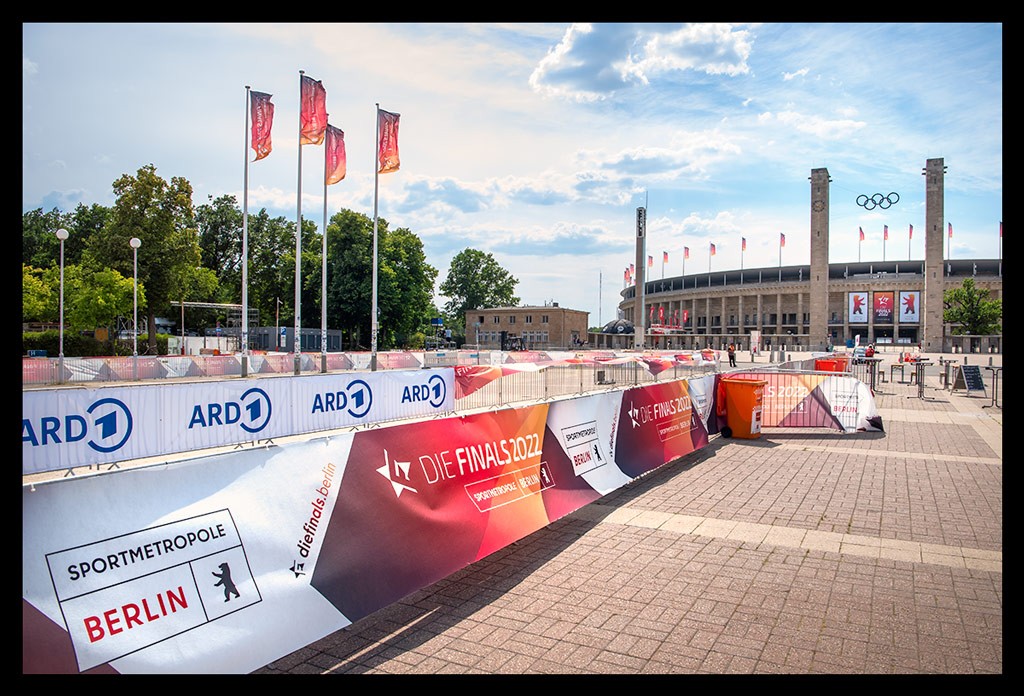 die finals 2022 berlin olympiastadion olympischer platz absperrung strecke triathlon mit blauem himmel multisport-event berlin sommerlich flaggen im wind