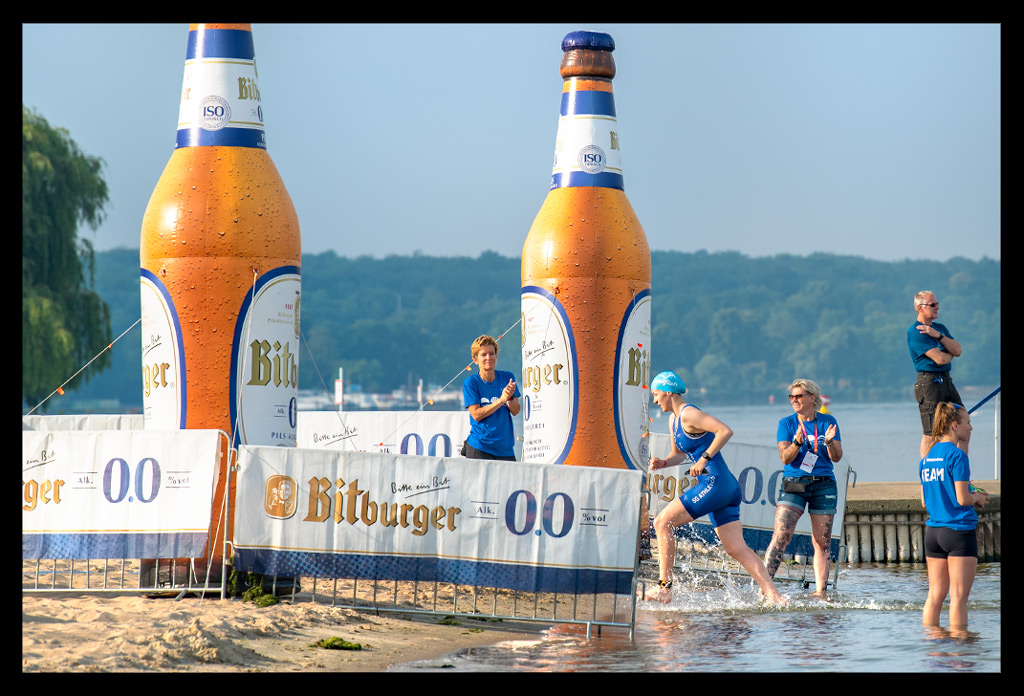 triatheten rennen aus wasser nach schwimmen dtu sprint deutsche meisterschaften strandbad wannsee berlin finals 2022 bitburger bierflaschen werbung am strand