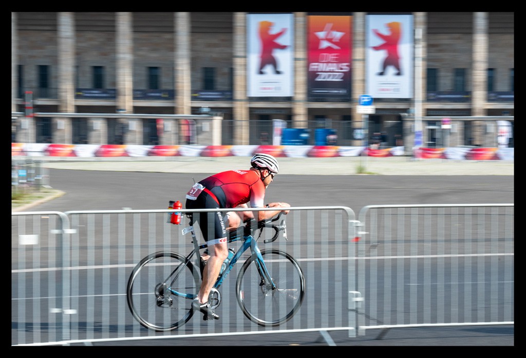 triathlet radstrecke vor olympiastadion berlin finals 2022 schnell unterwegs kämpferisch city triathlon bären sportmetropole werbung  absperrung