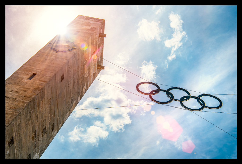olympiastadion berlin haupteingang turm uhr olympische ringe sommerlich wolken himmel sonnenstrahlen sunflare