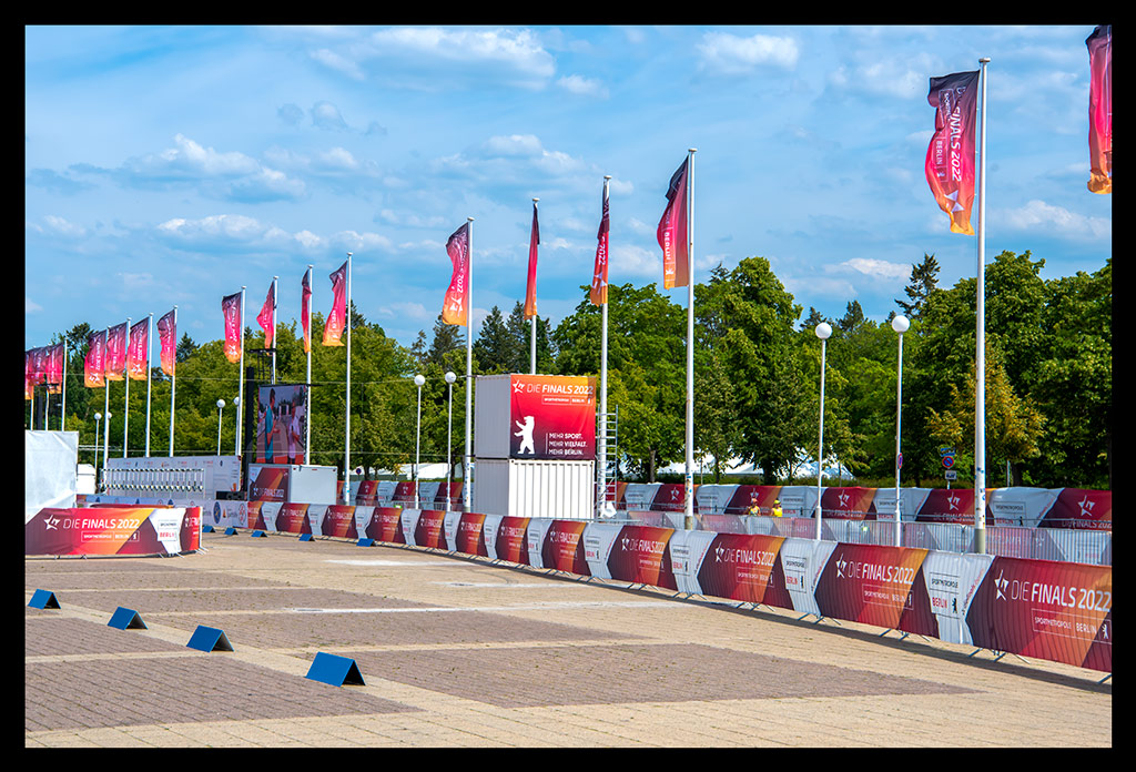 die finals 2022 berlin olympischer platz absperrung strecke triathlon mit blauem himmel multisport-event berlin sommerlich flaggen im wind