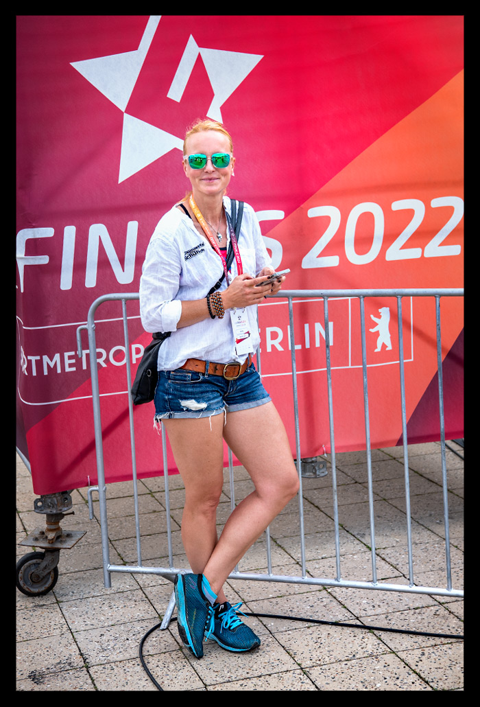 Olympischer platz finals berlin deutsche DTU meisterschaften Triathlon journalistin weiße bluse lächelt angelehnt Elite stadion multi-sportevent tribüne sommerlich