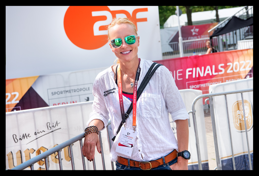 nadin als journalistin ARD ZDF bühne finals berlin berlin deutsche DTU meisterschaften Triathlon Sprintdistanz multi-sportevent weiße bluse jeans sonnenbrille lächelt