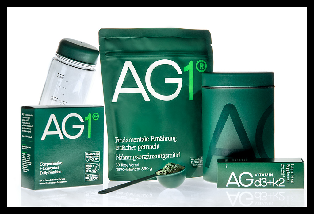 Athletic Greens AG1 Pulver als Gruppenbild mit allen Produkten eines Abos mit Flasche, Löffel, Becher, Vitamin D
