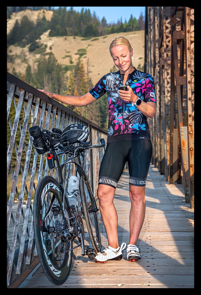 Nadin Eule Triathletin testet Garmin Edge 1040 SOLAR GPS-Radcomputer mit zeitfahrrad buntes radtrikot im sommerlichen Kanada auf Straße mit Landschaft Bergen seen Flüsse
