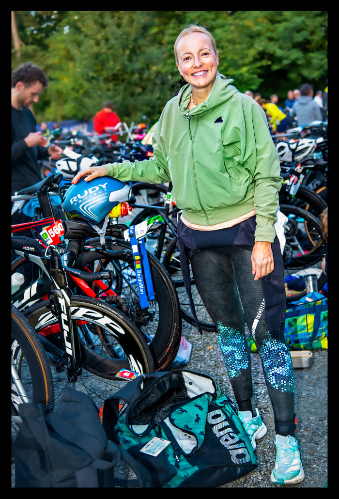 Triathlon beim BerlinWoMan-Triathlon im Wechselbereich an ihrem Zeitfahrrad stehend
